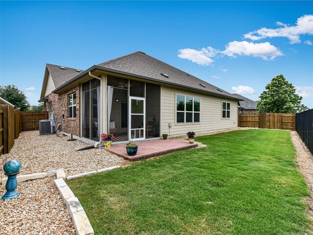 rear view of house featuring a sunroom, central air condition unit, a shingled roof, and brick siding