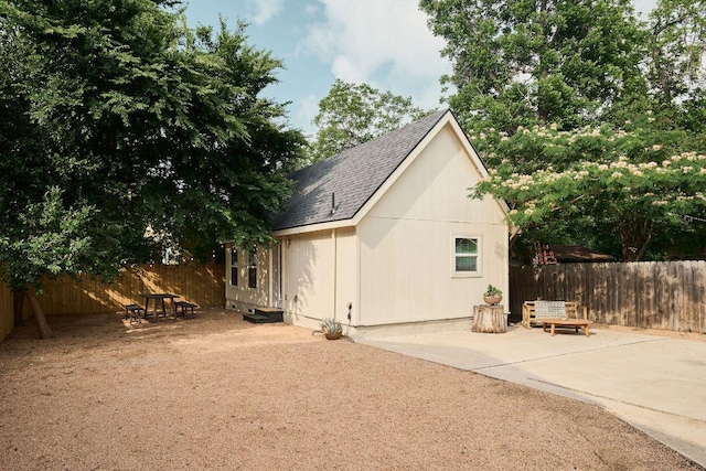 back of house featuring a shingled roof and a patio