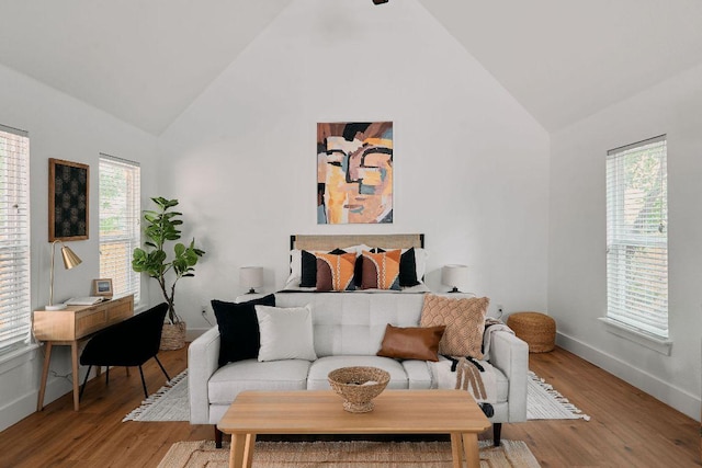living room with high vaulted ceiling, healthy amount of natural light, light wood finished floors, and baseboards