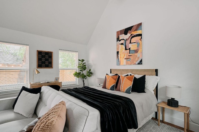 carpeted bedroom with high vaulted ceiling and baseboards