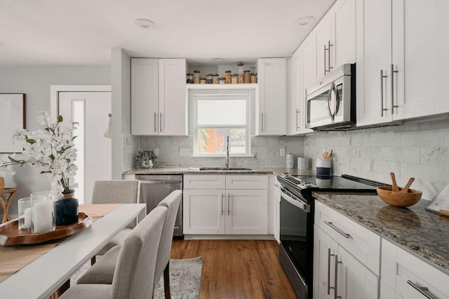 kitchen featuring stainless steel appliances, a sink, and white cabinets