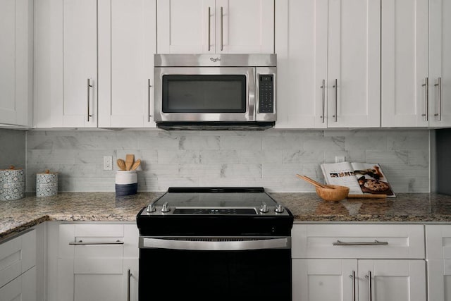 kitchen featuring stainless steel microwave, electric stove, and white cabinetry