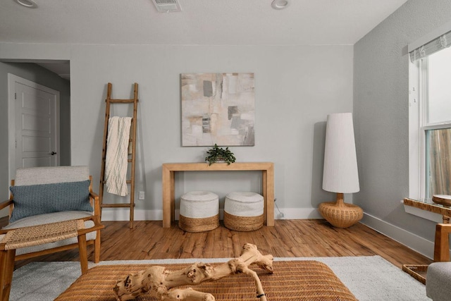 living area featuring baseboards and wood finished floors