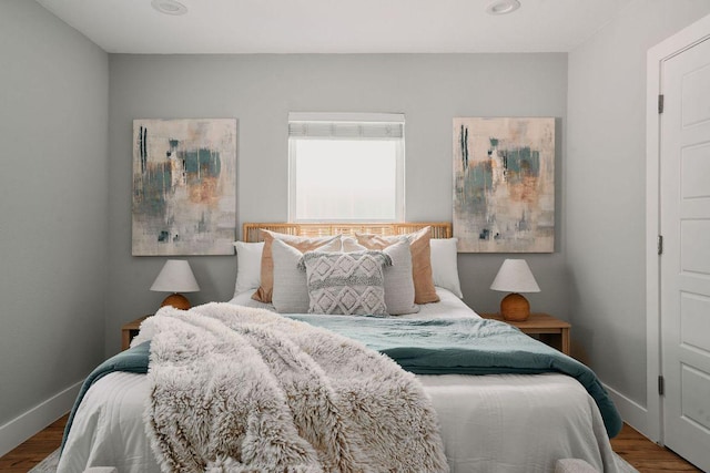 bedroom with wood finished floors and baseboards