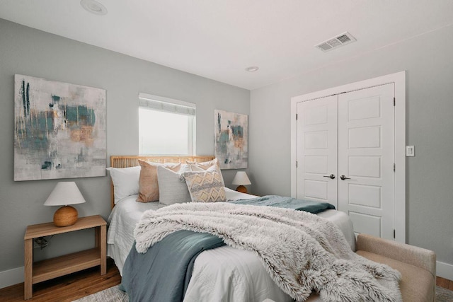 bedroom featuring wood finished floors, a closet, and baseboards