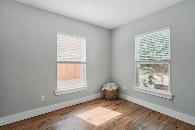 empty room with baseboards and wood finished floors