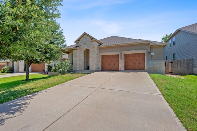 1180 Verna Brooks Way, Kyle, TX 78640 - view of front of property with stone siding, an attached garage, driveway, and a shingled roof