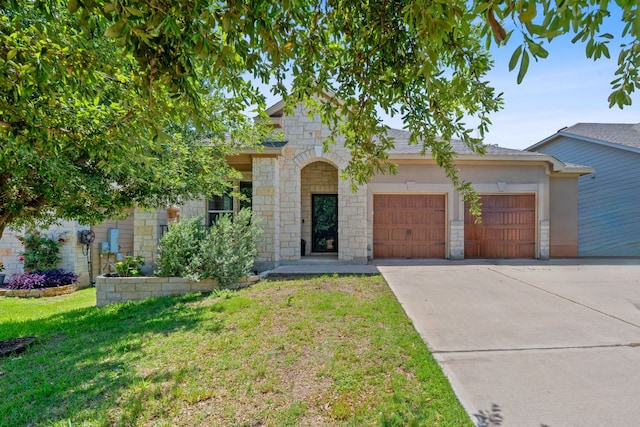 1180 Verna Brooks Way, Kyle, TX 78640 - view of front of home featuring stone siding, driveway, a garage, and a front yard