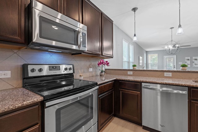 1180 Verna Brooks Way, Kyle, TX 78640 - kitchen featuring appliances with stainless steel finishes, dark brown cabinetry, a chandelier, and backsplash