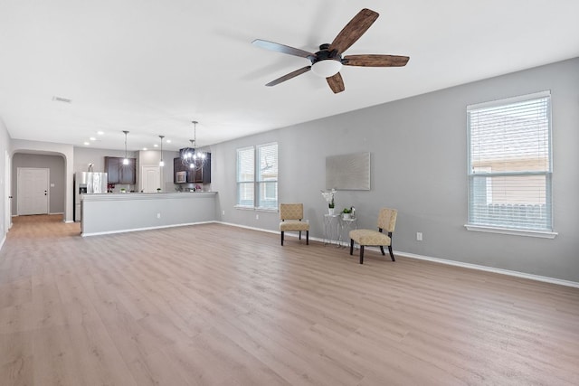 1180 Verna Brooks Way, Kyle, TX 78640 - living area featuring arched walkways, light wood-type flooring, baseboards, a ceiling fan, and recessed lighting