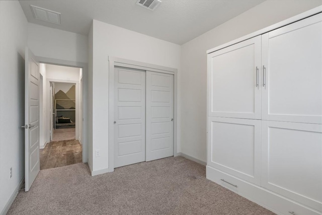 unfurnished bedroom with carpet flooring, a closet, and baseboards