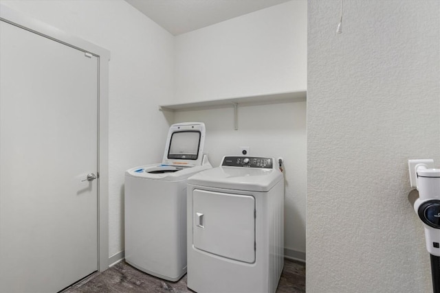 clothes washing area featuring washing machine and dryer and a textured wall