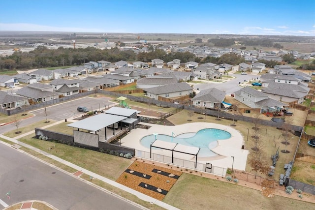 aerial view of property and surrounding area featuring a pool area and nearby suburban area