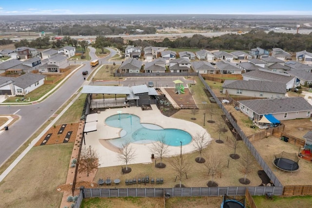 aerial view of property and surrounding area featuring a pool area and nearby suburban area