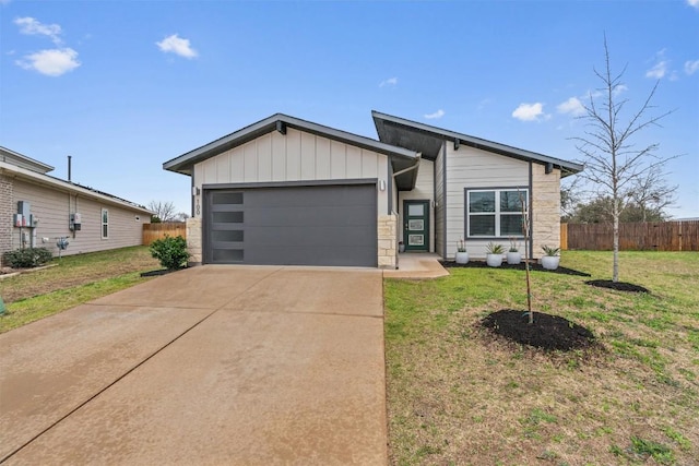 view of front of property with an attached garage, driveway, stone siding, and board and batten siding