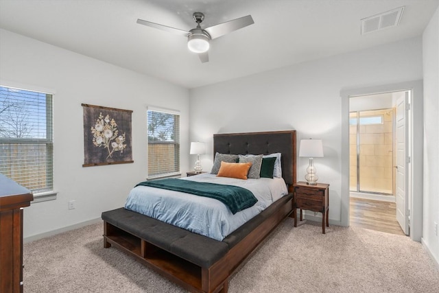 bedroom with light colored carpet, baseboards, ceiling fan, and ensuite bathroom