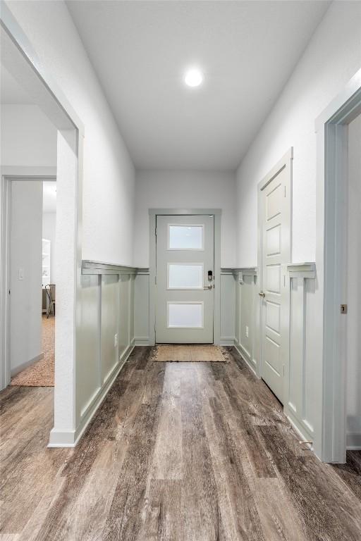 entryway with wood finished floors and wainscoting