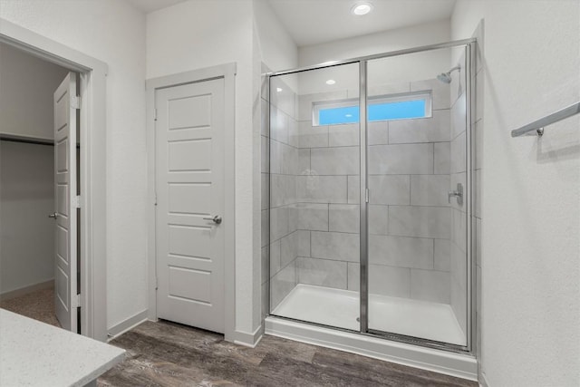 full bath with a shower stall, wood finished floors, baseboards, and recessed lighting