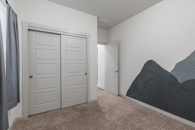 unfurnished bedroom featuring carpet flooring and a closet