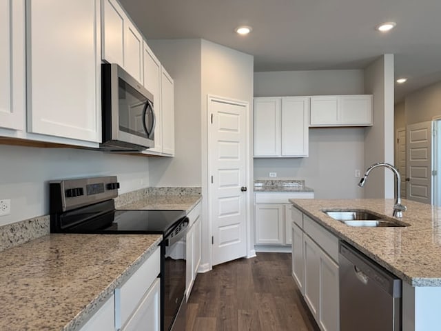 221 Escape Way, Jarrell, TX 76537 - kitchen with appliances with stainless steel finishes, a sink, dark wood-type flooring, white cabinetry, and light stone countertops
