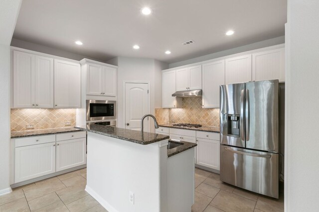 9617 Solana Vista Loop Unit A, Austin, TX 78750 - kitchen featuring appliances with stainless steel finishes, under cabinet range hood, light tile patterned floors, tasteful backsplash, and recessed lighting