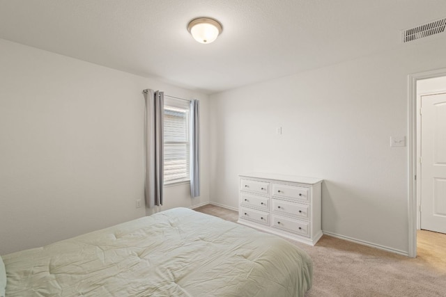 bedroom featuring light carpet and baseboards