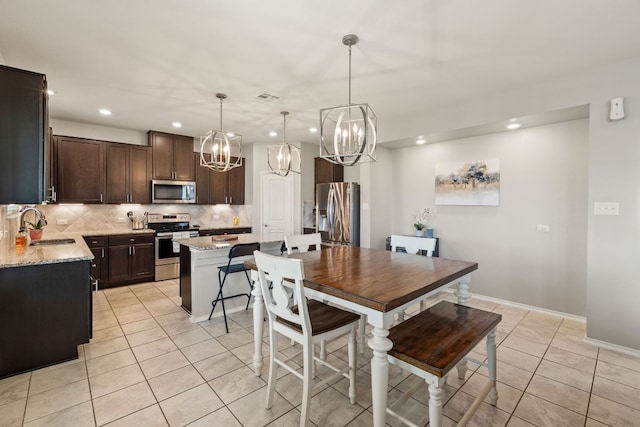 dining room featuring a chandelier, light tile patterned floors, recessed lighting, and baseboards