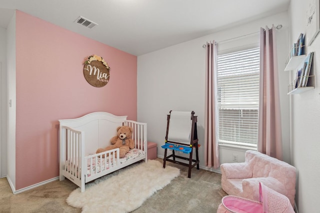 carpeted bedroom with a crib and baseboards