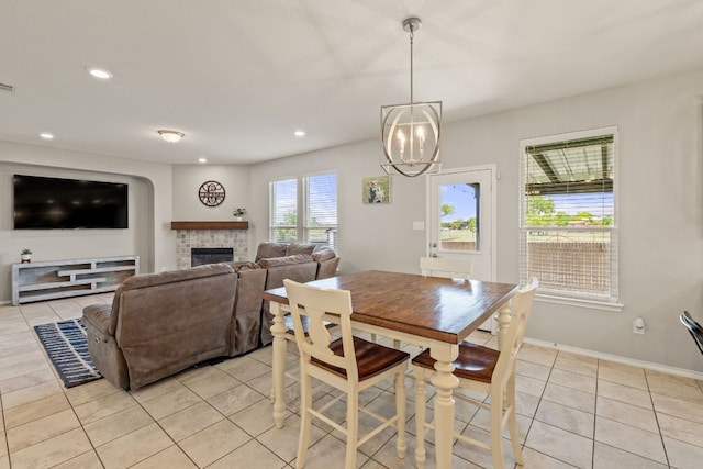 dining room featuring light tile patterned floors, a chandelier, a brick fireplace, recessed lighting, and baseboards