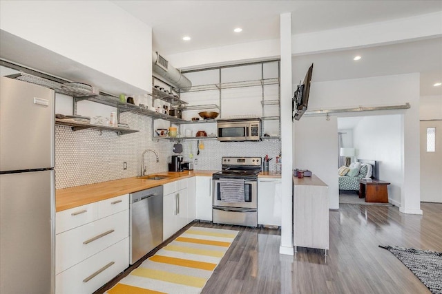 1304 Mariposa Dr Unit 214, Austin, TX 78704 - kitchen featuring appliances with stainless steel finishes, modern cabinets, white cabinetry, tasteful backsplash, and wood finished floors