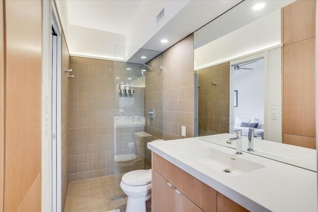 1304 Mariposa Dr Unit 215, Austin, TX 78704 - full bathroom featuring a walk in shower, toilet, vanity, tile walls, and recessed lighting