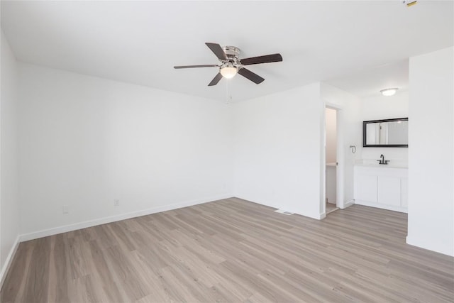 2201 Mission Hill Cir, Austin, TX 78741 - unfurnished room featuring light wood-style floors, a ceiling fan, and baseboards