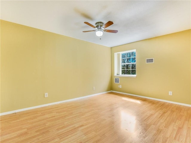 2201 Mission Hill Cir, Austin, TX 78741 - spare room with a ceiling fan, light wood-style flooring, and baseboards
