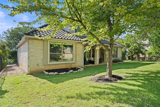 exterior space with stone siding, a tile roof, and outdoor lounge area