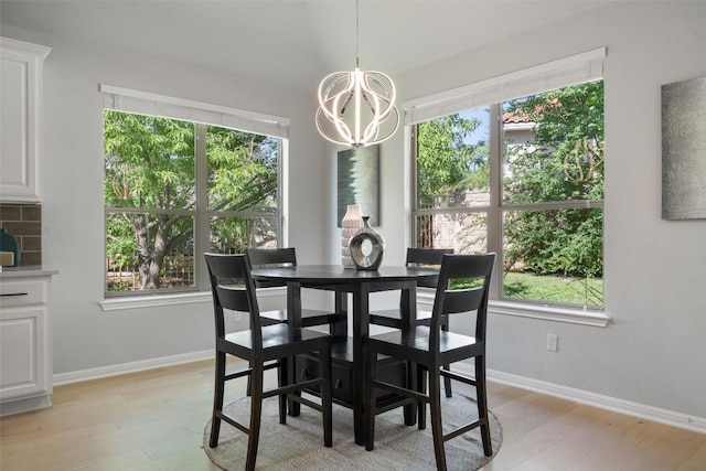 dining room with a chandelier, healthy amount of natural light, and baseboards