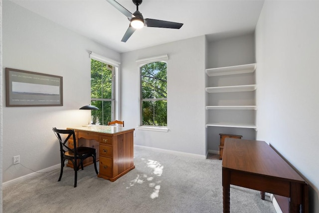 office area with carpet, a ceiling fan, and baseboards