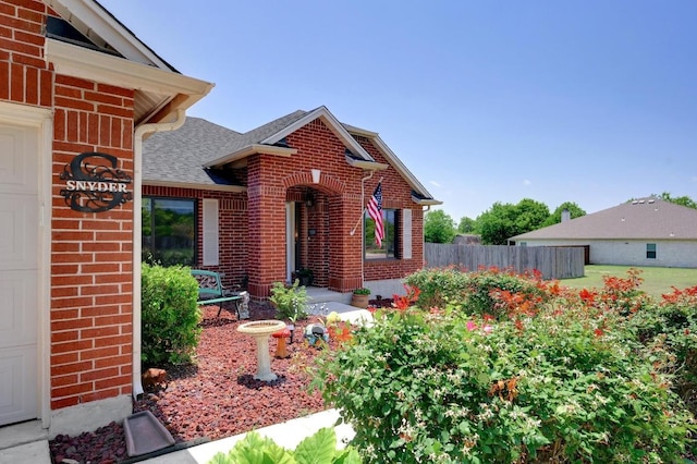 866 Bella Vista Cir, Kyle, TX 78640 - doorway to property featuring brick siding, fence, a garage, and roof with shingles
