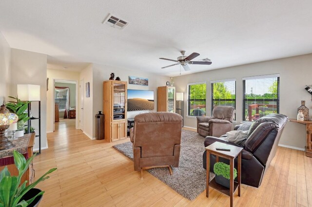 866 Bella Vista Cir, Kyle, TX 78640 - living room featuring a ceiling fan, baseboards, and light wood-type flooring