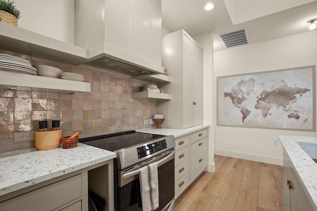 kitchen with open shelves, stainless steel electric range oven, light wood-style floors, decorative backsplash, and light stone countertops