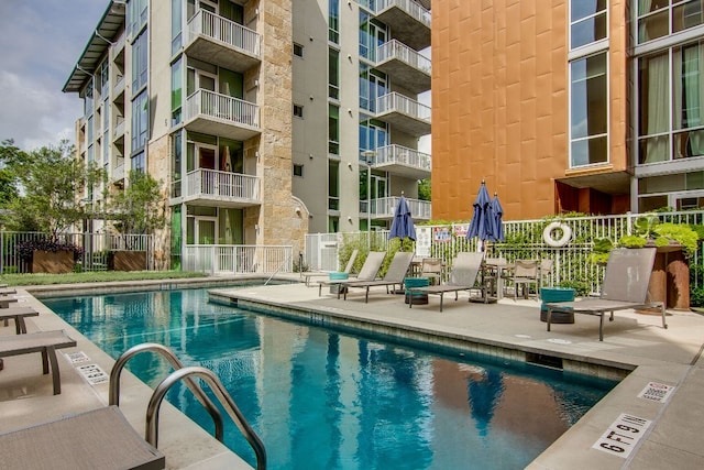 community pool with fence and a patio