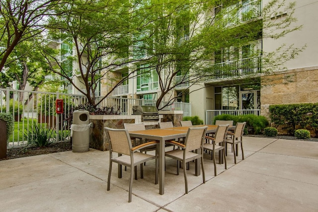 view of patio / terrace featuring outdoor dining space, area for grilling, fence, and a grill
