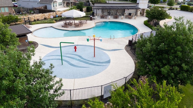 community pool with fence and a patio area