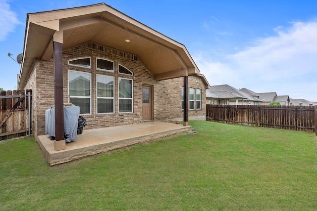 back of house with brick siding and a patio