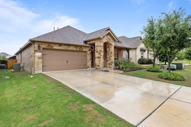 1012 Swan Flower St, Leander, TX 78641 - french country inspired facade with an attached garage, concrete driveway, a front yard, stone siding, and a shingled roof