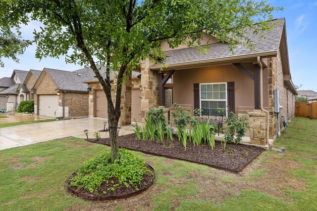 view of front of property with concrete driveway, stucco siding, stone siding, roof with shingles, and an attached garage