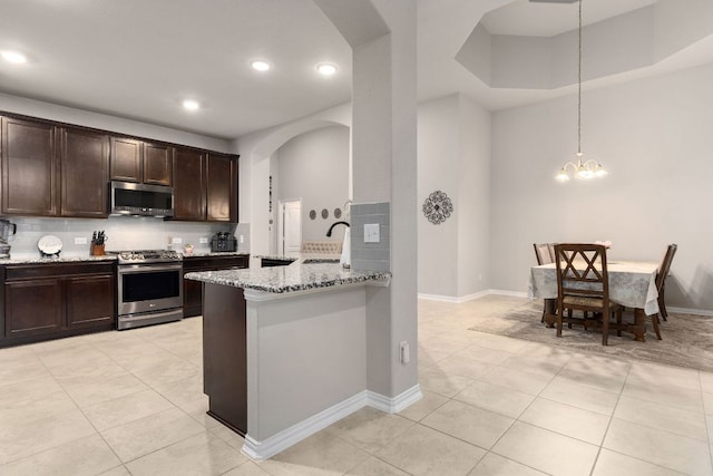 kitchen with stainless steel appliances, arched walkways, a sink, light tile patterned floors, and recessed lighting