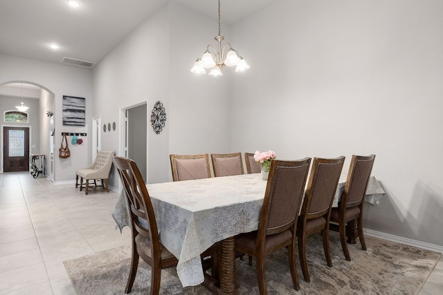 1012 Swan Flower St, Leander, TX 78641 - dining room featuring arched walkways, a chandelier, a towering ceiling, and light tile patterned floors