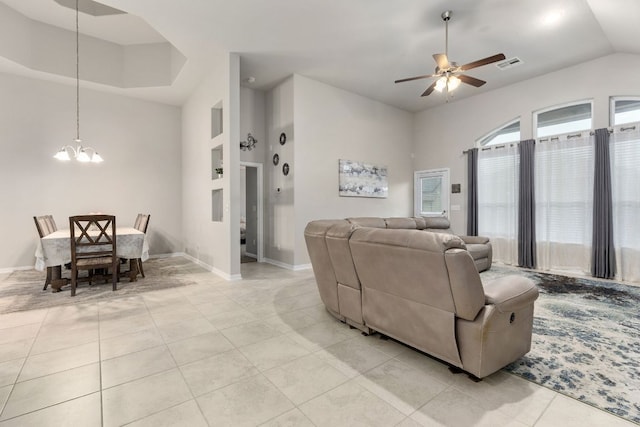 living area featuring a chandelier, light tile patterned floors, a ceiling fan, baseboards, and vaulted ceiling