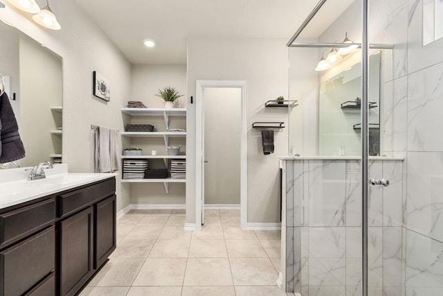 bathroom with a shower stall, vanity, tile patterned floors, baseboards, and recessed lighting