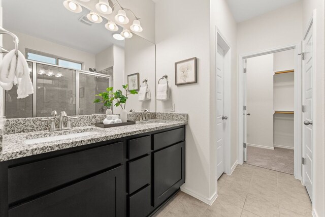 9528 Hunter Ln, Austin, TX 78748 - bathroom featuring double vanity, a shower stall, a spacious closet, and tile patterned floors
